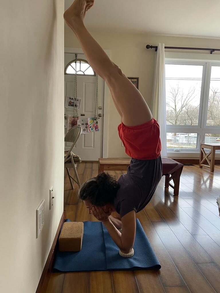 Netta Sella practicing an Iyengar yoga pose at the wall