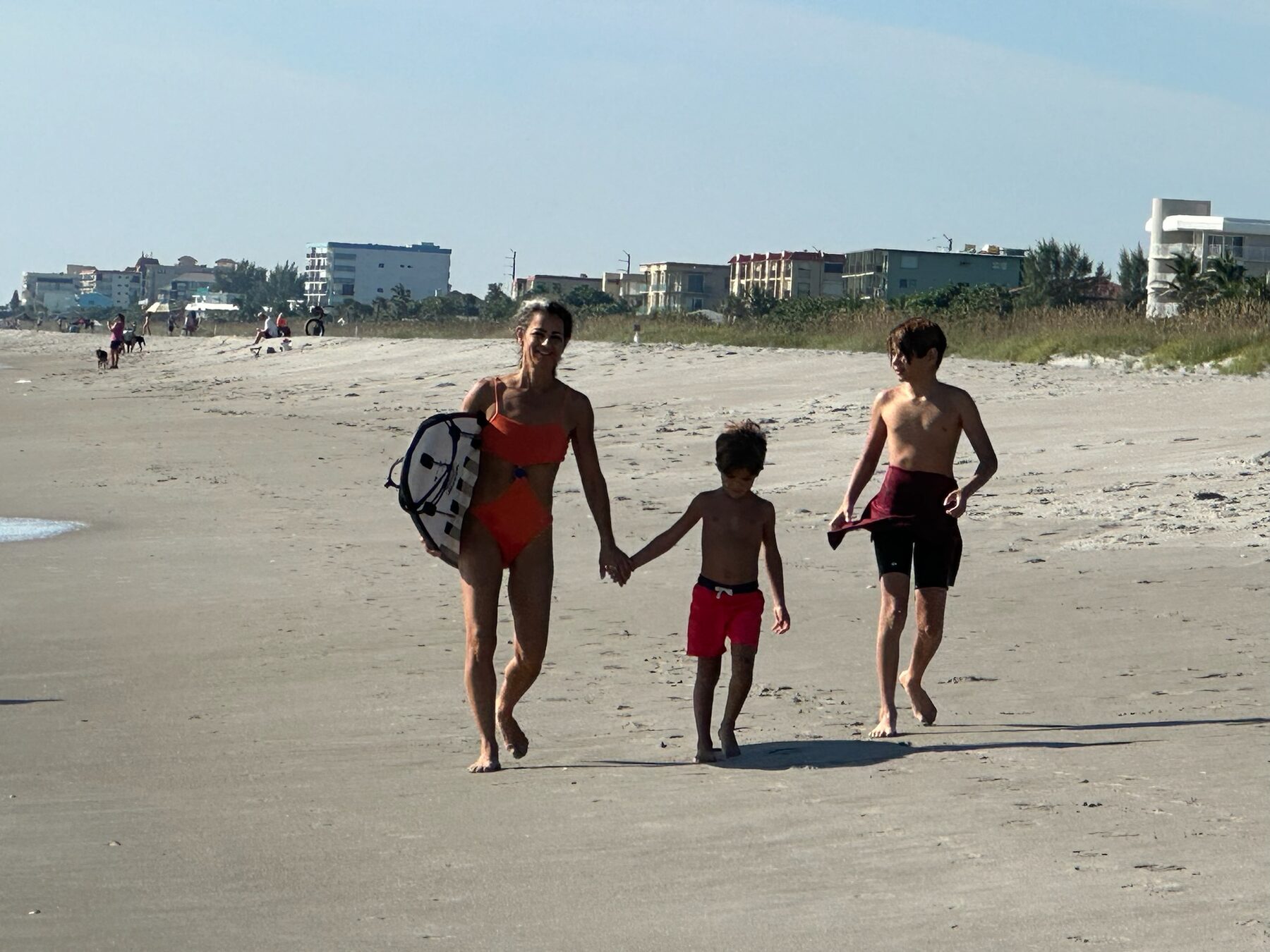 Netta Sella walking on Cocoa Beach with her two boys after a swim